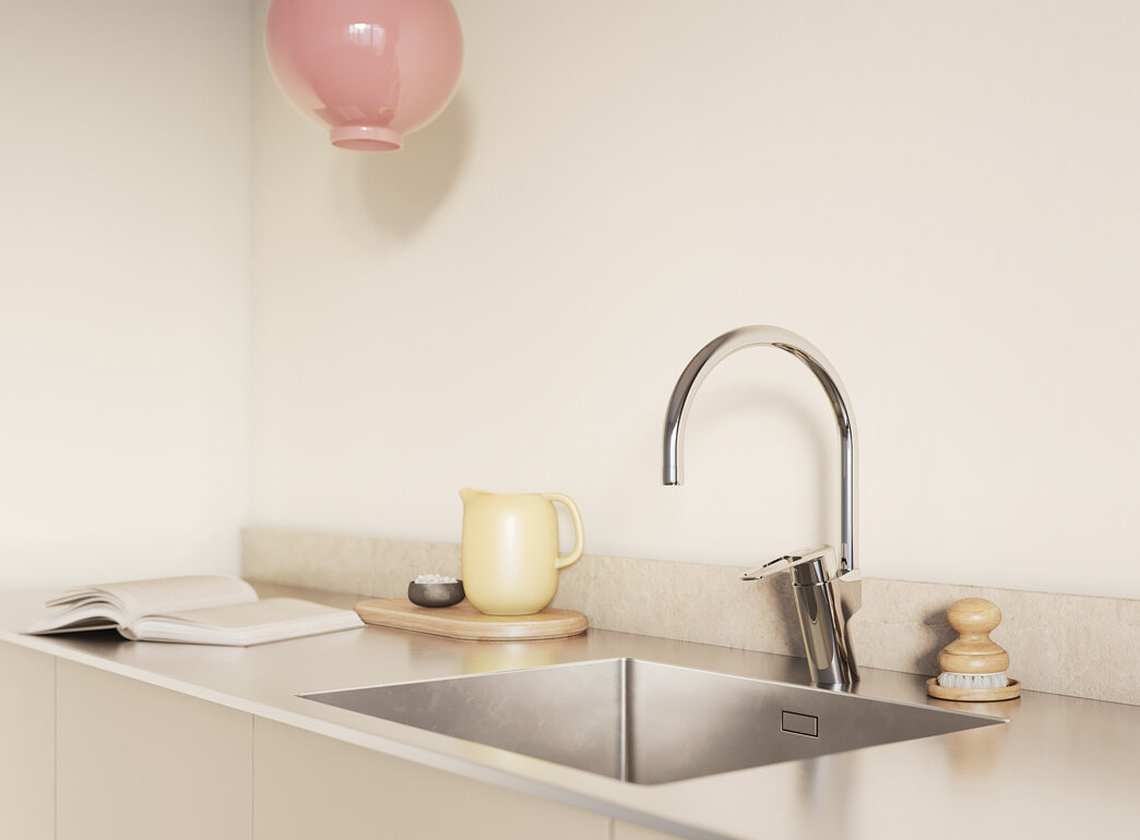 Minimalistiskt kök med ljusskåp, väggskåp i trä, två rosa taklampor och solljus som strömmar genom ett fönster.