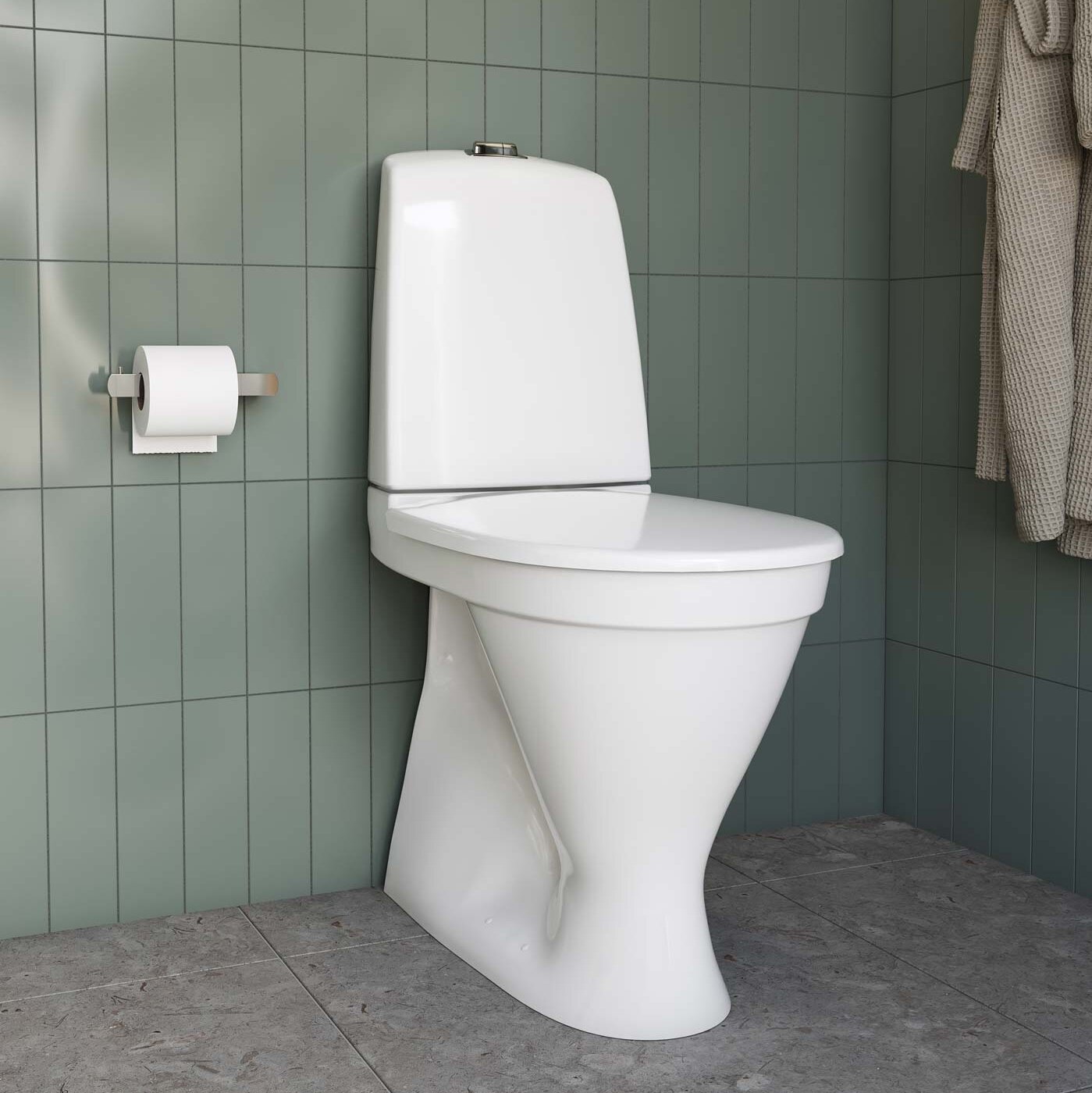Golvstående vit toalett i hög modell från Gustavsberg installerad i ett modernt badrum med svart kakel, med en växt till vänster.