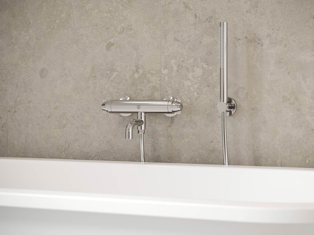 Chromuotas „Ducentic“ vonios maišytuvas ant plytų plytelėmis išklotos sienos.