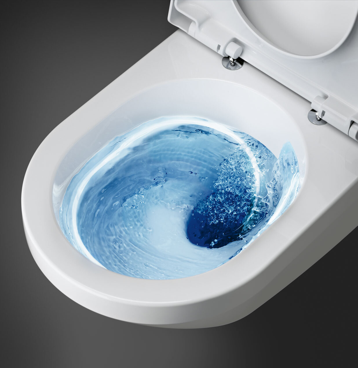 A white toilet with blue water swirling inside during flushing, viewed from above.