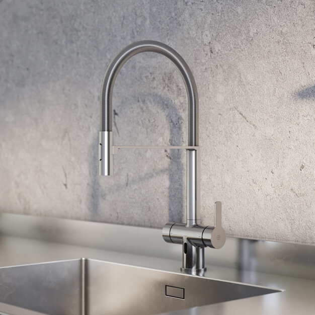 Ett modernt kök med en köksblandare i krom Matchad med en diskho i rostfritt stål, kompletterat med en ljus bänkskiva och grå strukturerad baksida. Hyllor prydda med dekor och växter ger en inbjudande bakgrund.