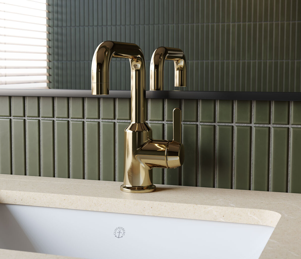 Mässingsblandare installerad på en beige bänkskiva med ett vitt handfat och grönt kaklat vägg i bakgrunden.
