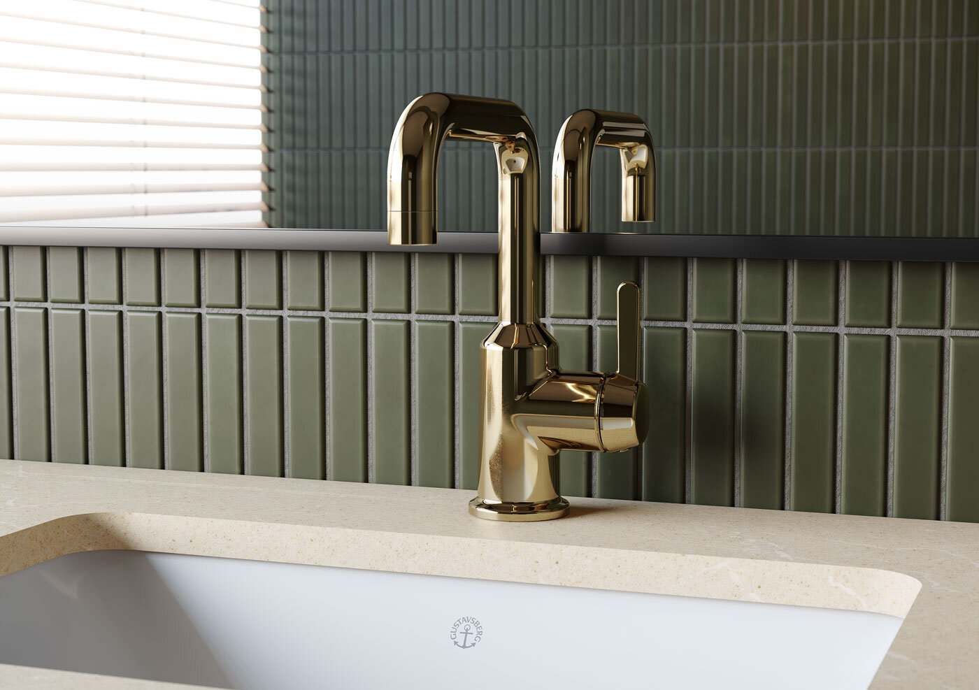 Mässingsblandare installerad på en beige bänkskiva med ett vitt handfat och grönt kaklat vägg i bakgrunden.