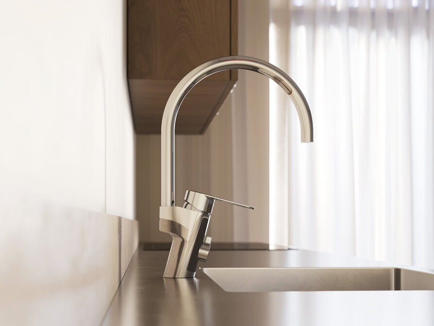 Närbild på en modern köksdiskbänk med en hög köksblandare i krom och naturligt ljus som kommer in genom tunna gardiner i bakgrunden.