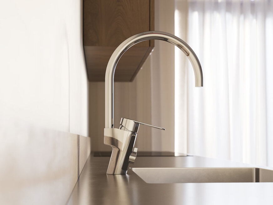 Närbild på en modern köksdiskbänk med en hög köksblandare i krom och naturligt ljus som kommer in genom tunna gardiner i bakgrunden.