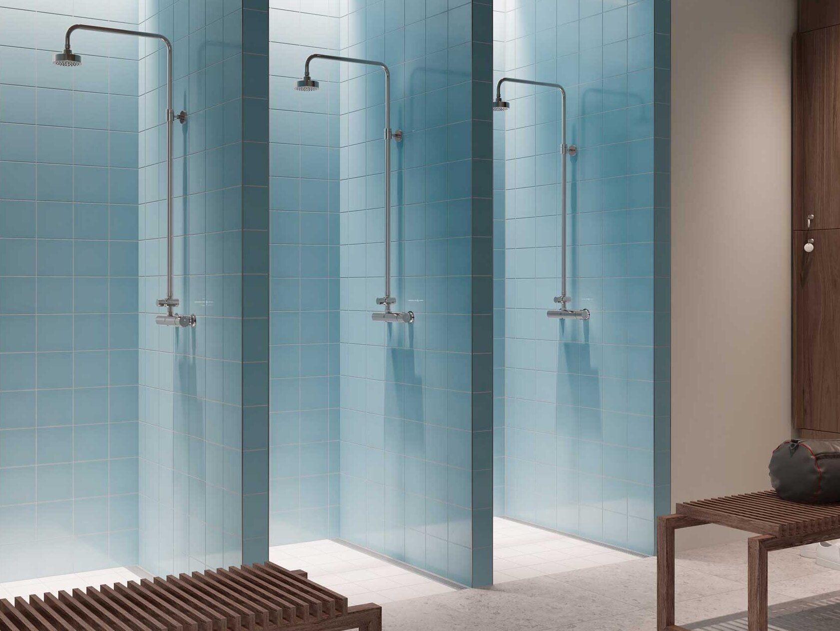 Three shower cubicles with glass walls and modern fixtures in a minimalist dressing room environment in blue and beige.