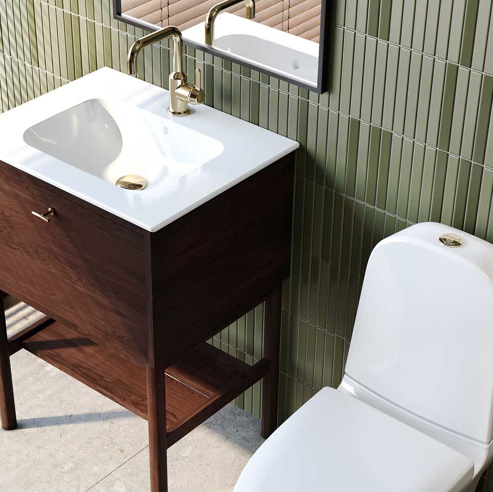 Kommod i mörk ek med handtag i mässing. Vitt handfat med bottenventil i mässing och två tvåhåls tvättställsblandare i mässing.