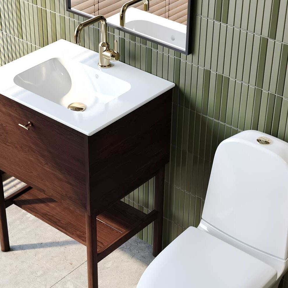 Dark oak chest of drawers with brass handles. White sink with brass bottom valve and two two-hole brass basin mixers.