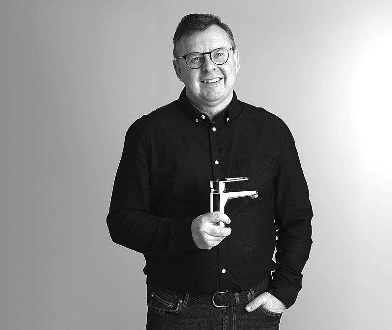 Mattias Virsgård, klädd i en blå skjorta, håller en Nautic blandare i krom.