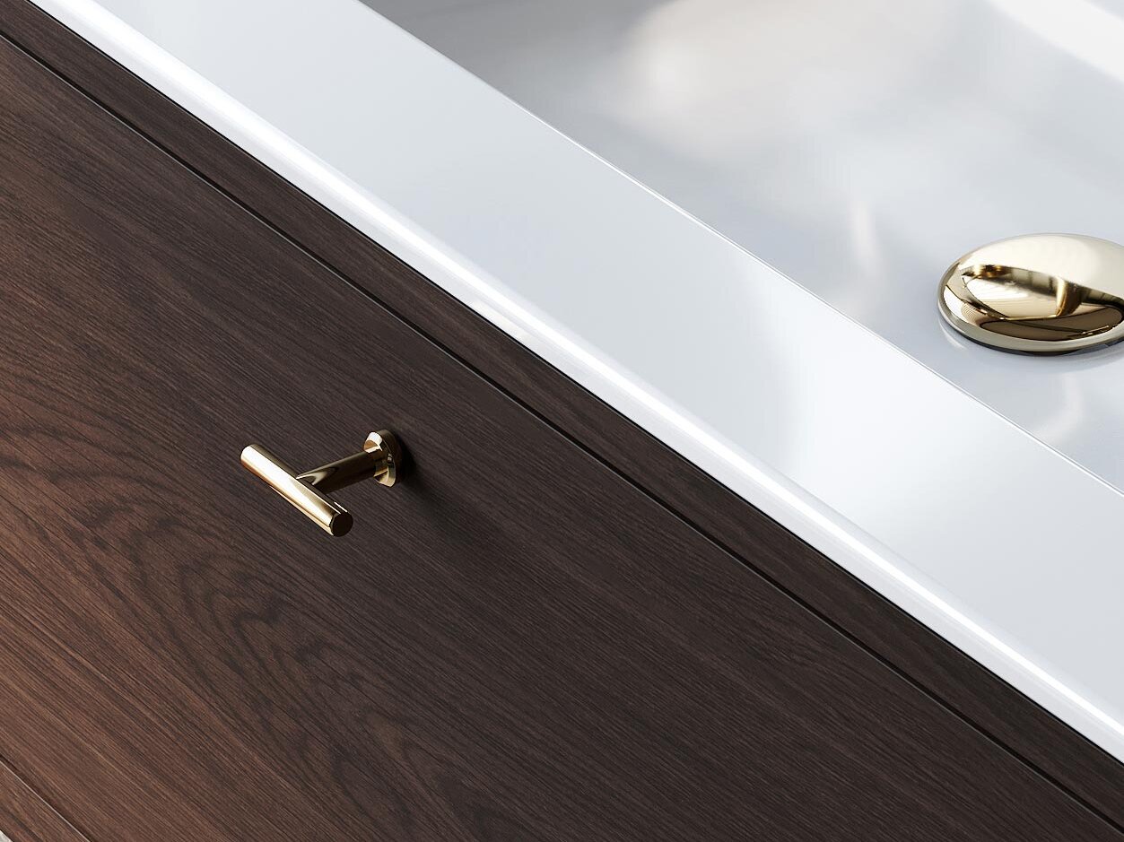 Närbild av ett handfat med en kran i mässing och ett handtag i mässing på en kommod i mörk ek.
