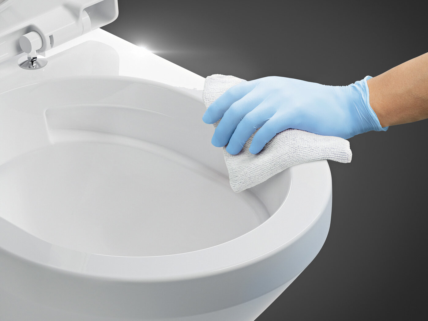 Sinistä muovikäsinettä käyttävä henkilö puhdistaa wc-kannen valkoisella liinalla.