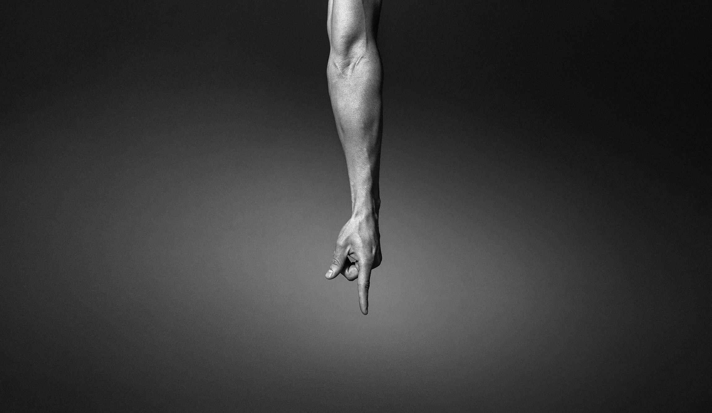 En arm sträcker sig nedåt från bildens överkant, med pekfingret pekande rakt nedåt – för att symbolisera spolning av en toalett.