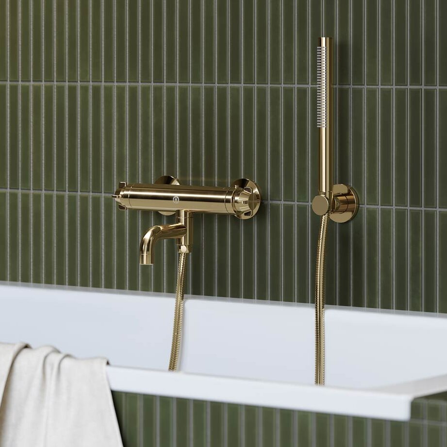 Žalvarinis „Ducentic“ vonios maišytuvas ant žaliomis plytelėmis išklijuotos sienos.