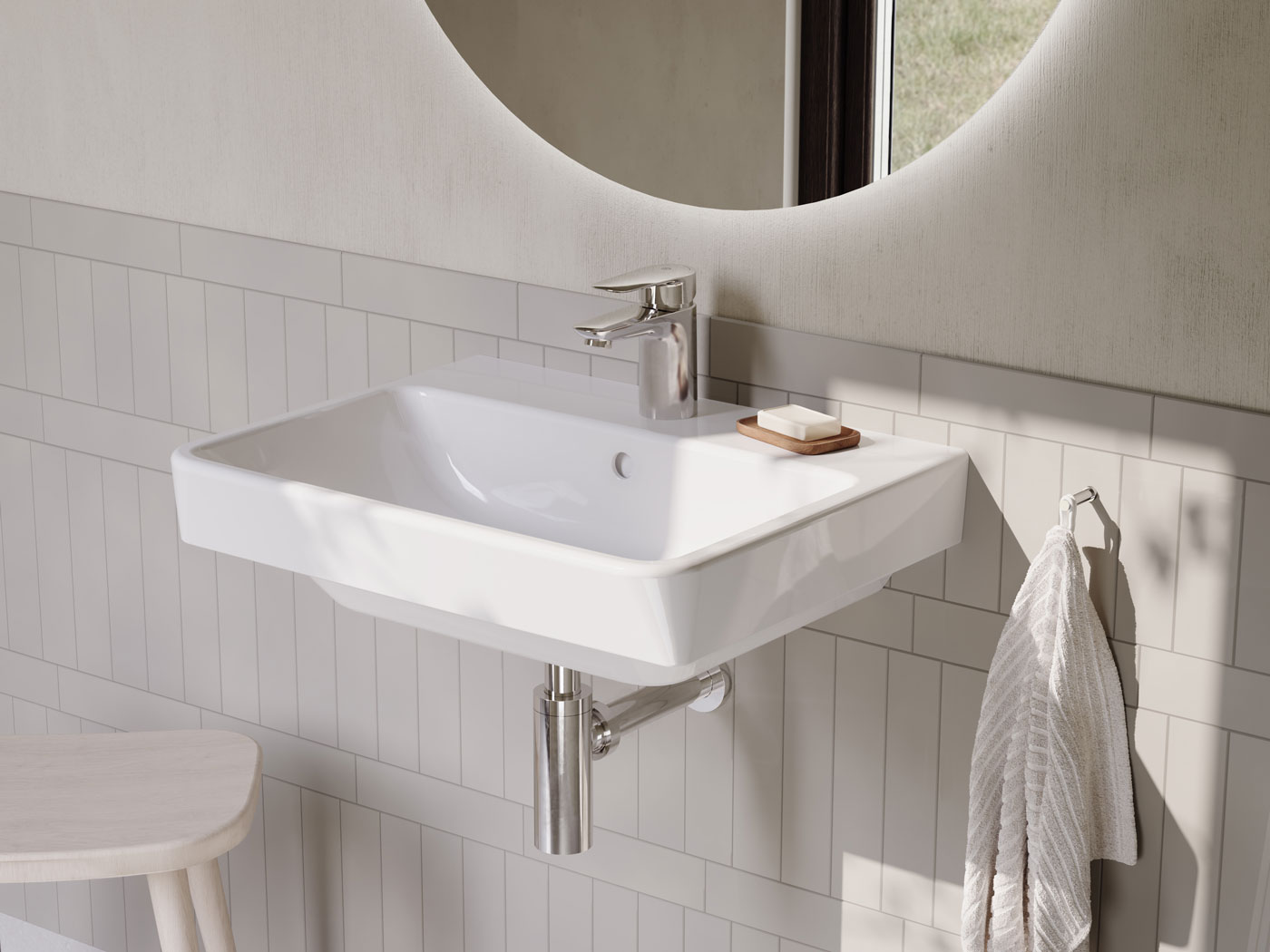 Atlantic tvättställ i vitt, belyst rund spegel ovanför.