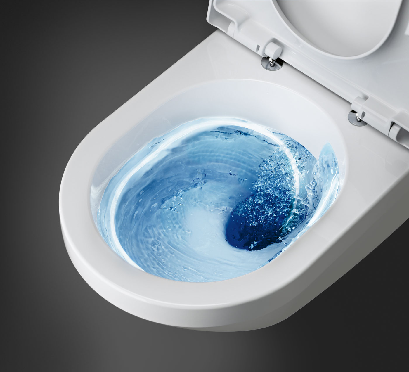 Valkoinen wc, jonka sisällä pyörii sinistä vettä huuhtelun aikana, ylhäältä katsottuna.